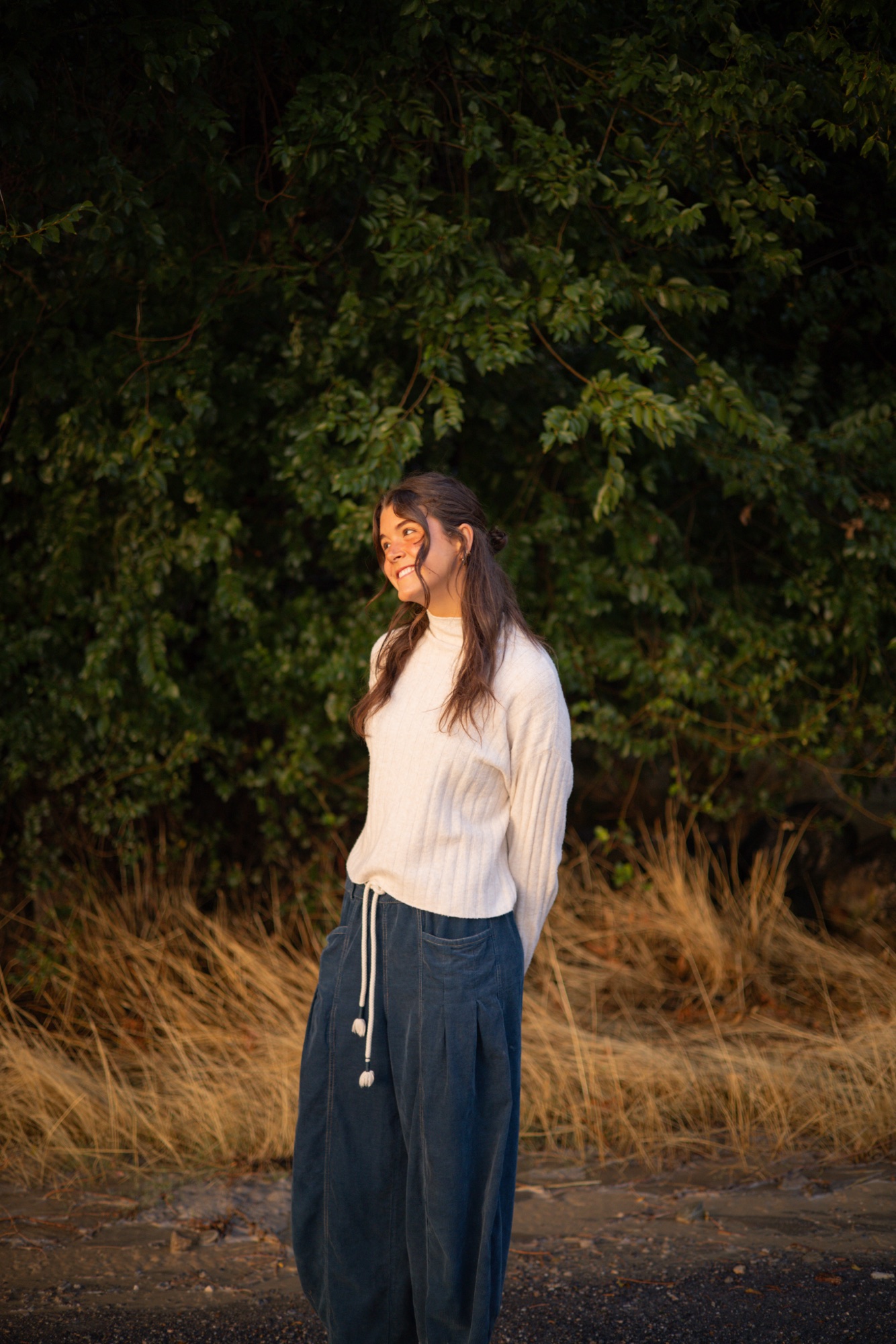 Kate, smiling outdoors at golden hour